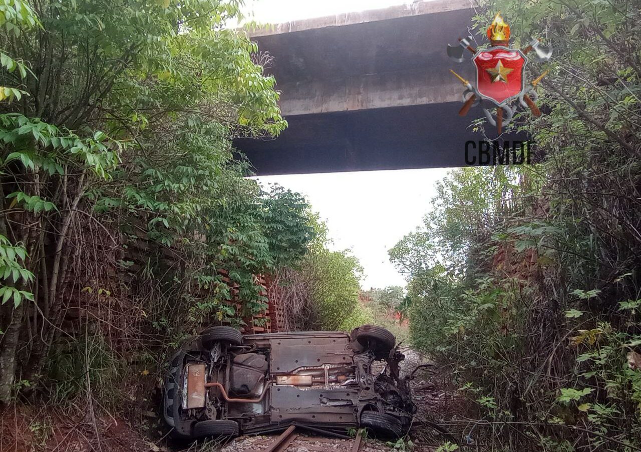 Carro sai da pista, colide com guad rail e cai de ponte sobre linha férrea, na DF 001